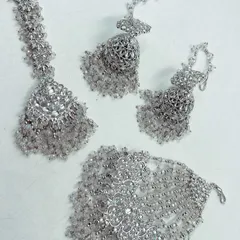 A stunning silver-toned jewellery set with clear beads, ideal for a modern Haldi or Mehendi look. This rental set includes a maang tikka, hathphool, and earrings.
