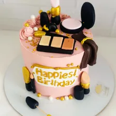 The perfect cake for a makeup artist or beauty lover, adorned with edible fondant lipstick, eyeshadow palettes, and brushes.