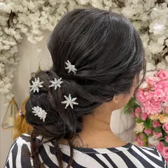 A classic Western-style low bun, perfect for a reception gown or a Christian wedding. The sparkling star accessories add a touch of whimsy and glamour.