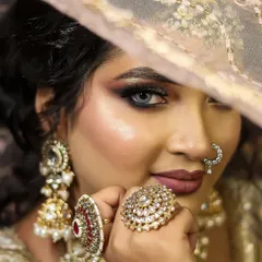 Mastering the art of the classic bridal look. This is a demonstration of a flawless, soft-glam bridal makeup, focusing on a radiant base, subtle smokey eyes, and elegant jewelry placement, a core skill in our curriculum.