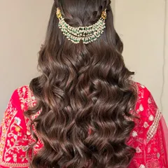 A beautiful half-up, half-down hairstyle with soft waves, perfect for a sangeet or engagement. The look is completed with a stunning piece of hair jewelry.