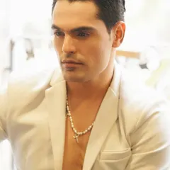 A confident and polished look. The focus is on flawless-looking skin and perfectly groomed, slicked-back hair, creating a powerful and sophisticated presence.