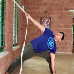 Using a strap as a prop in Parsvakonasana (Side Angle Pose) helps to extend the spine and open the chest, allowing for a deeper experience of the asana with proper support.