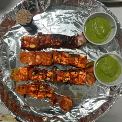 Delicious paneer tikka served with green chutney as a starter for a birthday party. The paneer is marinated and grilled to perfection.