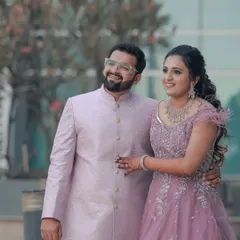 A happy, candid moment during an urban engagement shoot. The modern background contrasts beautifully with the couple's soft pastel outfits, creating a fresh and contemporary portrait.