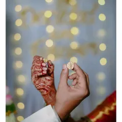 A beautiful detail shot from an engagement ceremony. The couple's hands come together to show off their new rings, with a soft, romantic bokeh background.