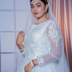This portrait shot highlights the detailed embroidery on the bodice of the Christian bridal gown and the elegant matching accessories.