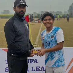 A coach presents a trophy to one of our U-14 players. We recognize and celebrate individual contributions to the team's success.