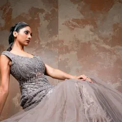 A seated pose that offers a different perspective on the gown. This shot highlights the detailed bodice and creates a feeling of relaxed glamour, perfect for an editorial story.