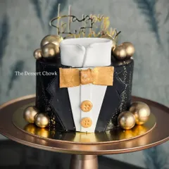 A sharp and stylish tuxedo cake, perfect for the gentleman in your life. This tall chocolate truffle cake is decorated in black and gold for a sophisticated look.