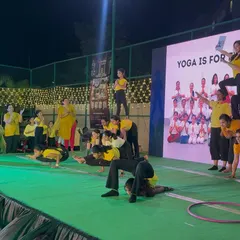 The kids and adults forming a human pyramid during a yoga event, a beautiful display of teamwork, trust, and community.