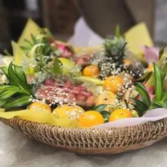 A close-up of our beautifully curated fruit basket. This view highlights the freshness of the strawberries, oranges, and mangoes, all nestled in a rustic woven basket.