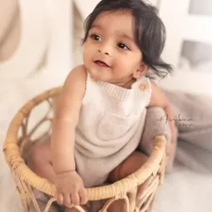 A classic sitter portrait of a smiling baby in a rustic wicker basket. These sessions, best between 8-10 months, are perfect for capturing your baby's emerging personality.