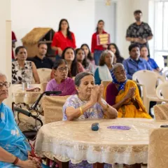 A resident claps along, fully immersed in the music during our 'Togetherness Initiative' performance. It's moments like these that show the universal language of music and its ability to bring joy and create shared experiences.