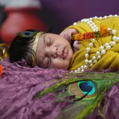 A close-up portrait of a newborn as Krishna, focusing on the peaceful sleep and delicate features, adorned with a pearl necklace and peacock feather.