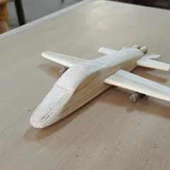 A handmade wooden airplane, crafted from pine. The simple, sturdy design makes it a perfect toy, built to withstand countless hours of imaginative play.