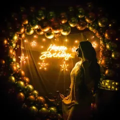 I love how creative you can get with photos in the theatre. The glow from the 'Happy Birthday' neon sign and the balloon arch creates a perfect backdrop. This is a great example of a birthday photoshoot before the movie starts.
