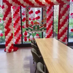 Another view of the balloon arch and branded photo booth setup for RedTape's office event. The red and white balloon theme was chosen to align with the company's branding.