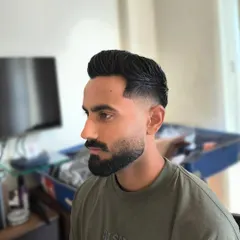 A sharp haircut with a perfectly groomed beard. The clean line-up on the cheeks and neckline is essential for making this style look polished and intentional.