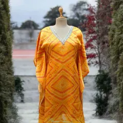 This yellow bandhani print kaftan combines effortless elegance with supreme comfort. The V-neck is adorned with delicate embroidery, making it a perfect choice for a breezy day or a festive look.