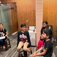 An instructor smiles as she watches over a group of young students, creating a warm and encouraging atmosphere for learning.
