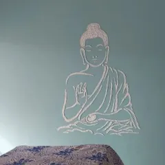 A textured stencil of a meditating Buddha on a soft blue wall, adding both visual and tactile dimension to this peaceful design.
