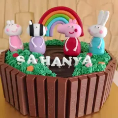 Here's a fun Peppa Pig cake, perfect for a toddler's birthday. I used KitKats to create a playful fence around a muddy puddle scene, with hand-molded fondant figures of Peppa and her friends under a bright rainbow.