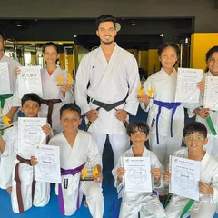 A group of our dedicated students proudly displaying their new belts and certificates after a successful grading test.