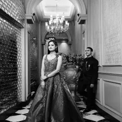 A grand, full-length portrait in a luxurious hallway. This black and white shot emphasizes the elegance of the couple's attire and the opulent surroundings.