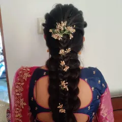 This intricate braid combines different weaving techniques and is accessorized with small, delicate flowers for a modern yet traditional feel. It's a beautiful choice for a wedding guest.