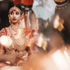 A beautiful candid portrait of a South Indian bride during her wedding ceremony. The soft focus and warm lighting highlight her attentive expression as she participates in the rituals.