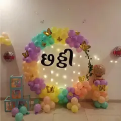 A colorful Chhatthi ceremony decoration. This setup features a circular balloon arch in pastel colors, fairy lights, and the word "Chhatthi" in Hindi script at the center.