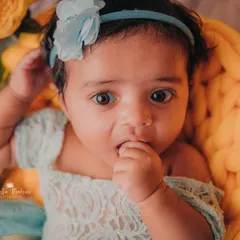 A tiny hand to the mouth is one of the cutest baby poses. This 3-month-old girl was a natural in front of the camera.