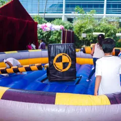 An inflatable wipeout-style game where kids have to jump and duck to avoid a rotating arm, testing their agility and timing.