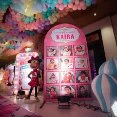 A personalized photo display for the birthday girl's "One-derful Year," set next to a Minnie Mouse prop and a welcome sign.