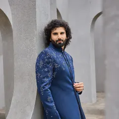 This shot showcases the sharp tailoring and fit of the navy bandhgala. The embroidery on the shoulder adds a point of interest without overwhelming the classic silhouette.