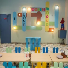 Our "I Love Wobble World" light-up sign is a favorite photo spot. This area shows our dedicated kid-friendly seating, perfect for party meals and activities.