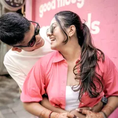 A fun and playful candid shot taken at a quirky cafe in Mumbai. This photo captures the couple's joyful energy and is a great example of a casual urban pre-wedding shoot.