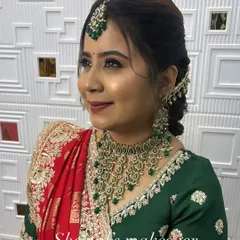 A close-up of a beautiful Gujarati bride's makeup. The look is completed with a traditional 'chandlo' and stunning green jewellery.