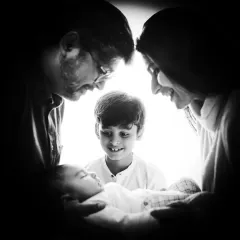 A beautiful black and white photo where the family forms a circle of light around their new baby. This artistic shot symbolizes the love and protection surrounding the newborn.