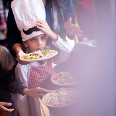 Event photography is about more than just posed pictures. It's about capturing the story of the day, like this little chef waiting to bake his own pizza at his birthday party. I focus on these candid, in-between moments that truly show a child's personality.