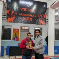 A singles participant being awarded his trophy in front of the V3 Academy banner. These events provide a great way for corporate employees to de-stress and compete.