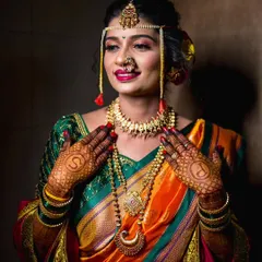A beautiful portrait of a Maharashtrian bride, focusing on her traditional jewelry like the Nath and Mundavalya, and her elaborate mehndi design.