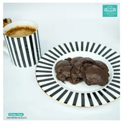 Our rich, dark chocolate cookies served on a plate next to a cup of coffee. It's the perfect pairing for a relaxing break.