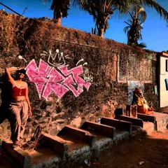 Me striking a pose next to my pink graffiti piece on a rustic wall at Versova beach. The salt, sand, and chaos of the city are the perfect backdrop for street art.