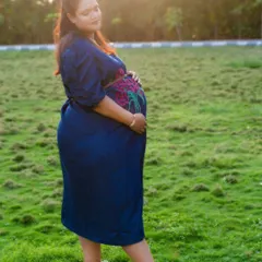 An outdoor maternity portrait taken during the golden hour. The warm sunlight and natural surroundings create a serene and beautiful atmosphere.