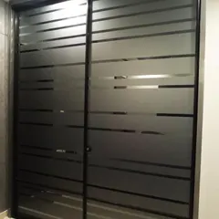 A modern Aristo wardrobe with frosted glass sliding doors. The horizontal stripes create a sleek, contemporary look while concealing the storage space behind it.