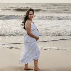 There's nothing like a walk on the beach for a maternity session. The mom-to-be looks so peaceful in her simple white dress with the waves in the background. It’s a perfect, serene moment captured by the sea.