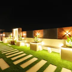 The illuminated pathway and built-in seating in the Sushant Lok terrace garden. The planters also feature integrated lighting for a layered effect.