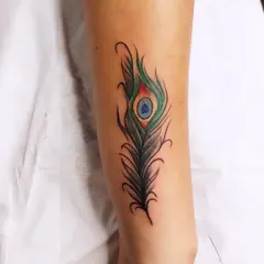 A vibrant peacock feather design was used to completely cover an old name tattoo on the forearm. The rich greens and blues, combined with fine-line details, make for a beautiful and effective cover-up that gives the client a fresh start.